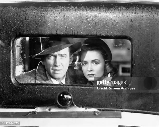 James Stewart and Donna Reed look out of the back window of vintage car in a scene from the Frank Capra directed movie 'Its A Wonderful Life' 1946.