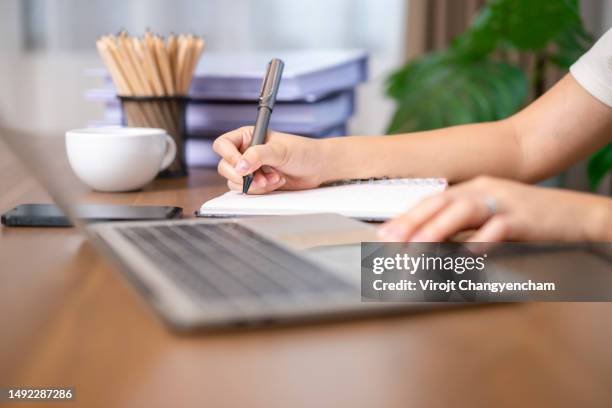 hand holding pen and writing on book - schedule stock pictures, royalty-free photos & images