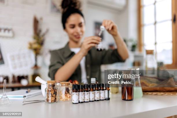 young female small business owner working at her home based cosmetic workshop - biological product stock pictures, royalty-free photos & images