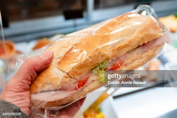 hand holding fresh sandwich, buying food for take away - buying lunch stock-fotos und bilder