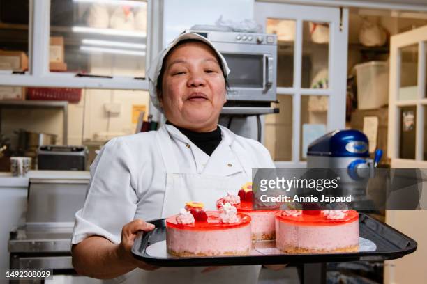 happy pastry chef woman holding a tray with strawberry cheese cakes - cheesecake white stock pictures, royalty-free photos & images