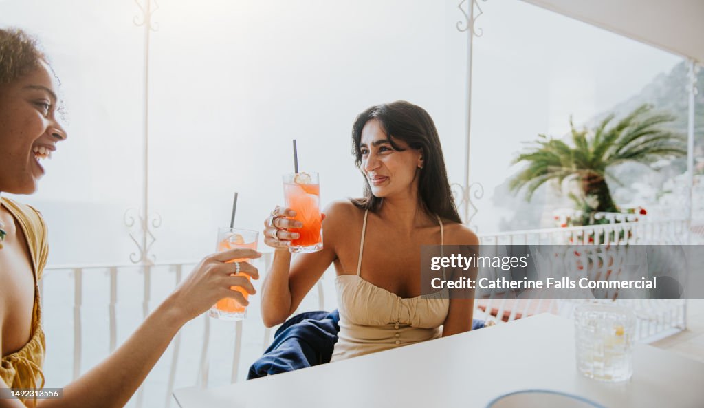 Female friends enjoy a cocktail in an al fresco dining experience