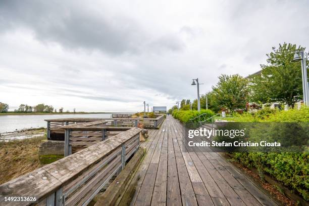wooden deck promenade along the riverfront of steveston village, british columbia, canada - richmond-colombie-britannique photos et images de collection