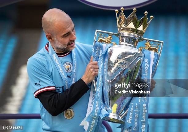 Manchester City manager Pep Guardiola poses with the Premier League trophy after the Premier League match between Manchester City and Chelsea FC at...