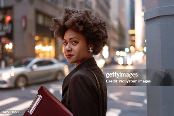 imprenditrice afroamericana multitasking: in attesa di un taxi a wall street, controllo delle e-mail - distretto finanziario di manhattan foto e immagini stock