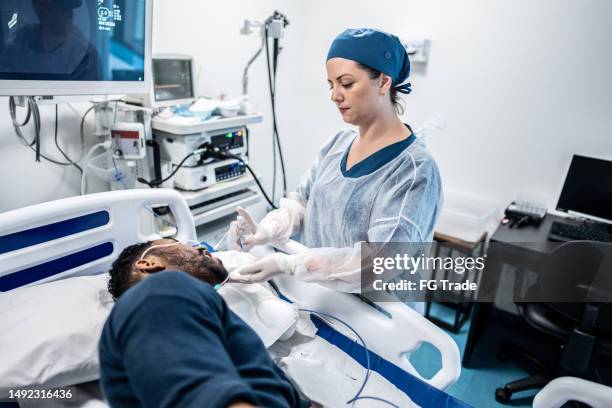 doctor spraying medicine in patient's mouth - endoscope stock pictures, royalty-free photos & images