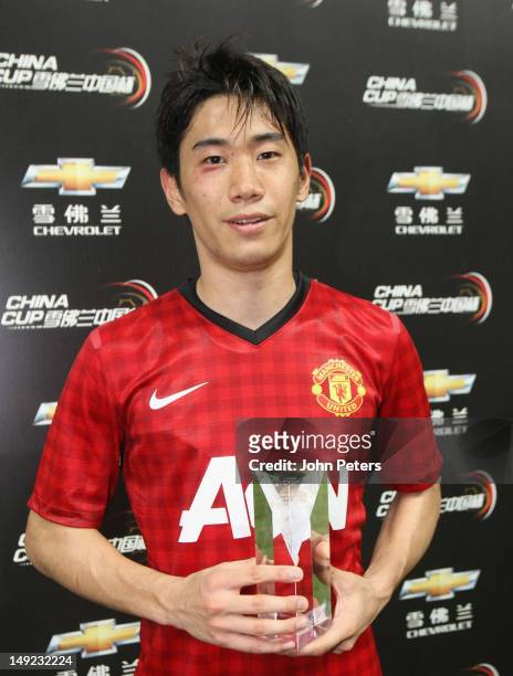 Shinji Kagawa of Manchester United poses with his Man of the Match award after the pre-season friendly match between Shanghai Shenhua and Manchester...