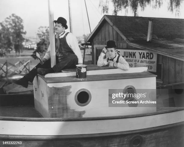 Towed in a Hole Stan Laurel and Oliver Hardy mending sailboat in Junk from the 1932 comedy.