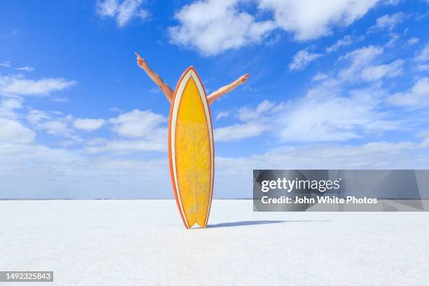 surfer with a retro yellow surfboard. hands out stretched celebrating. being carefree and having fun. salt lake. australian. south australia. - curiosity stock pictures, royalty-free photos & images