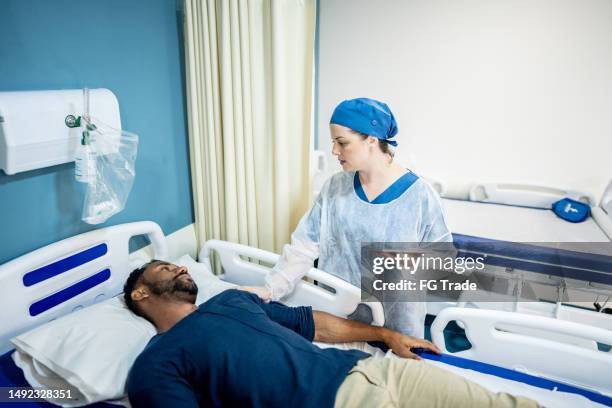 arzt im gespräch mit dem patienten und mit dem digitalen tablet im krankenhaus - chirurgenkappe stock-fotos und bilder