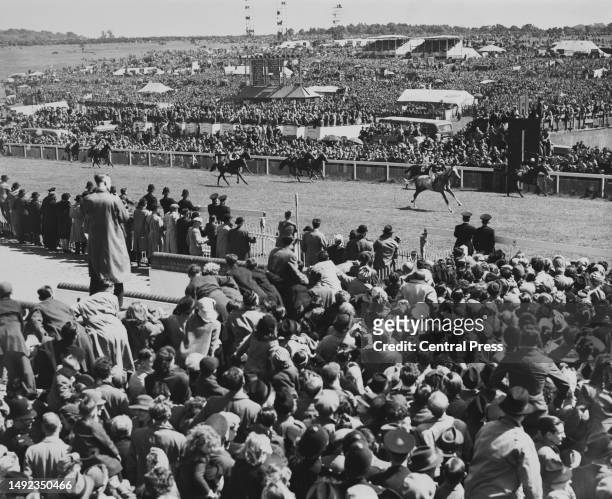 The crowd of spectators look on as Airbourne ridden by jockey Tommy Lowrey wins the Epsom Derby horse race from Harry Wragg on Gulf Stream on 6th...