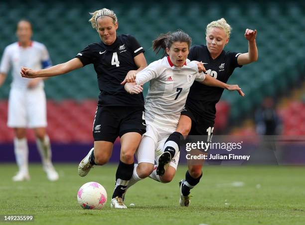 Katie Hoyle of New Zealand and Betsy Hassett of New Zealand challenge Karen Carney of Great Britain during the Women's Football first round Group E...