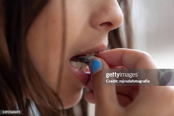 close-up of a girl eating sunflower seed - zonnebloempit stockfoto's en -beelden