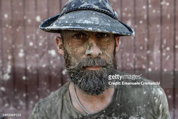Volunteer, his face covered in mud, poses for a portrait on May 22, 2023 in Forlì, Italy. Fifteen people have died and forty thousands have been...