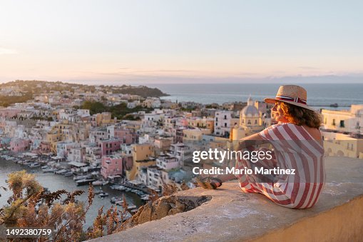 Mature woman admiring Procida sunset cityscape Mature woman admiring Procida sunset cityscape