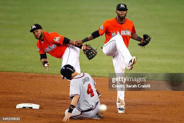 Paul Janish of the Atlanta Braves is forced out at second by Emilio Bonifacio of the Miami Marlins and Jose Reyes during a game at Marlins Park on...