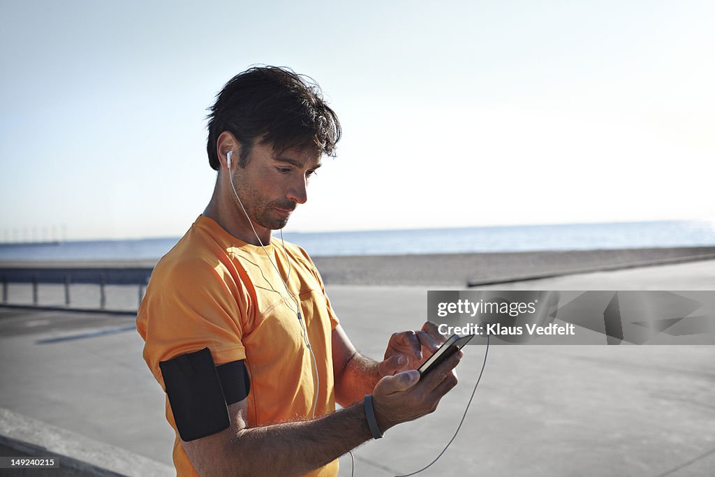 Male runner tjecking results on his smartphone