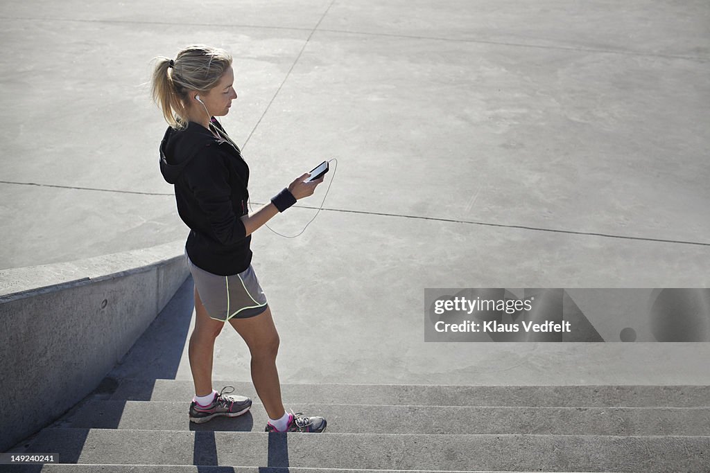 Female runner tjecking results on her smartphone