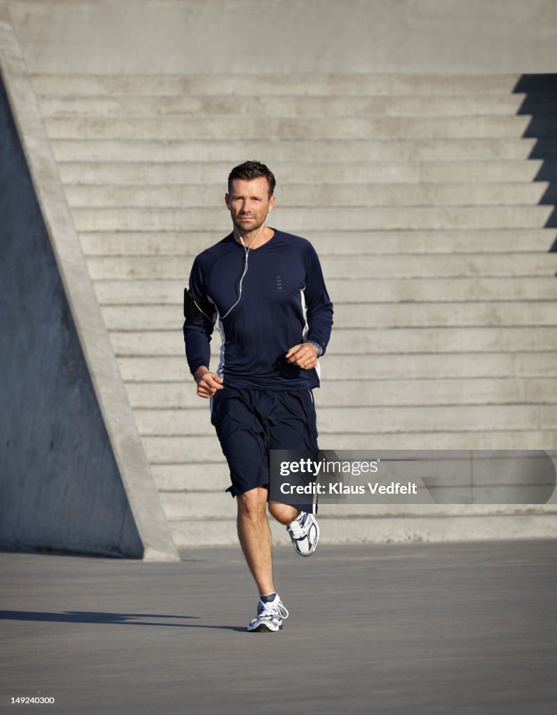 Man running with headphones, Stairs in background