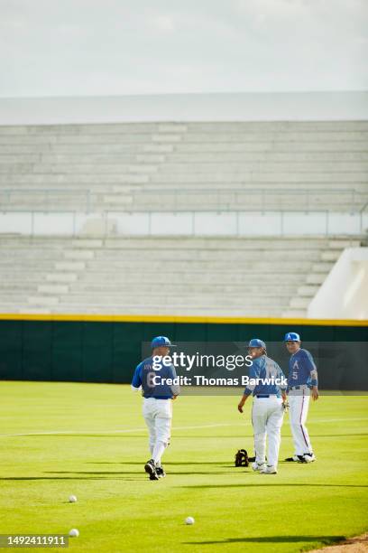 wide shot baseball teammate warming up on stadium field before game - catchers mitt stock pictures, royalty-free photos & images