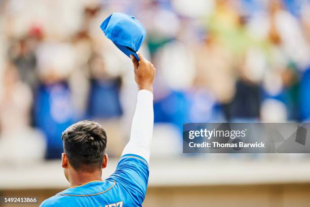 medium shot pitcher raising cap to fans after winning baseball game - athletics stadium stock pictures, royalty-free photos & images