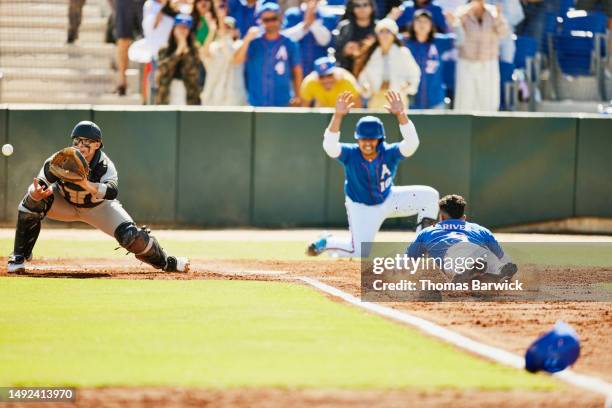 wide shot runner trying to beat tag from catcher during baseball game - catchers mitt stock pictures, royalty-free photos & images