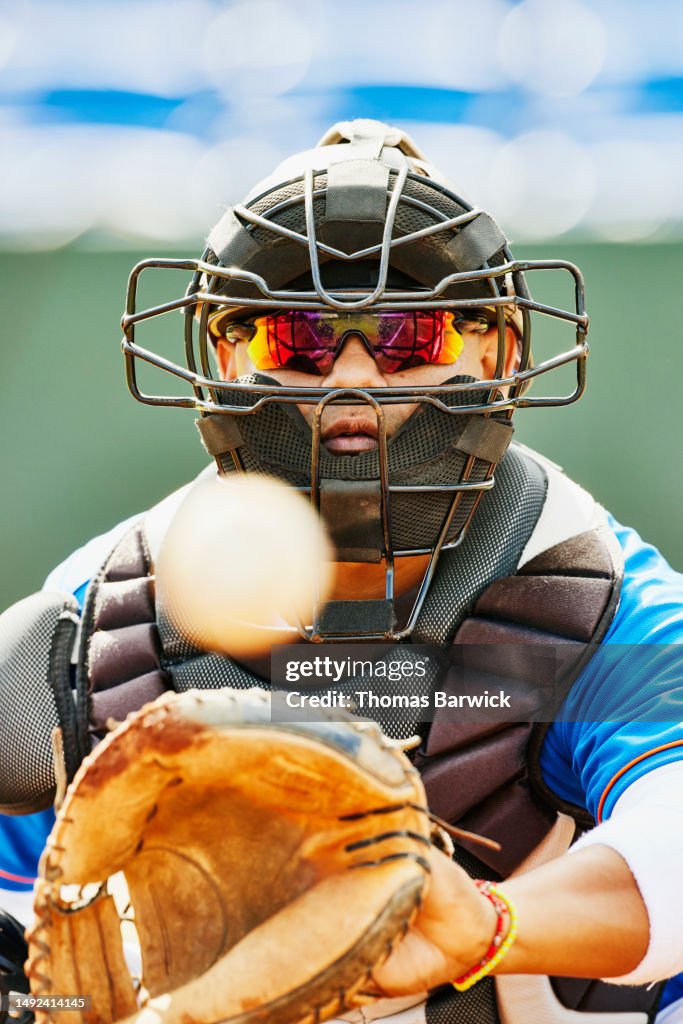 Medium close up catcher catching pitch during baseball game in stadium