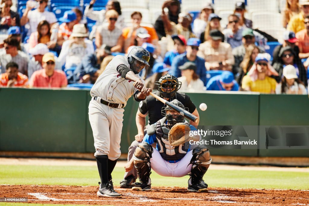Wide shot of batter hitting pitch during professional baseball game