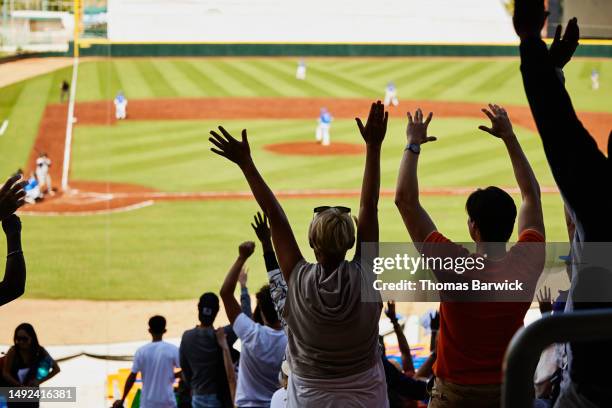 wide shot stadium crowd standing and cheering baseball team during game - baseball stock pictures, royalty-free photos & images