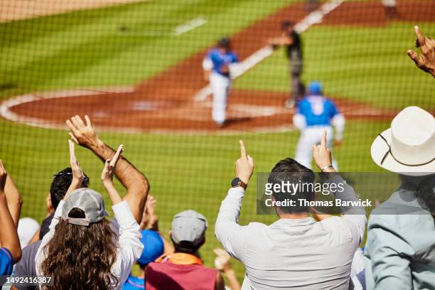 medium shot crowd cheering baseball player after hitting home run - baseball crowd stock-fotos und bilder