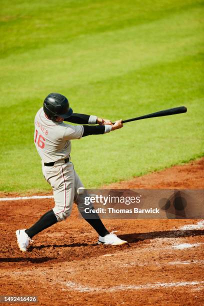 wide shot of swinging strike by batter during baseball game - baseball player hitting ball stock pictures, royalty-free photos & images