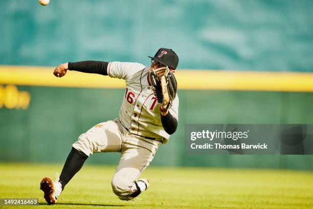 wide shot outfielder sliding for catch during baseball game in stadium - baseball sport stock pictures, royalty-free photos & images