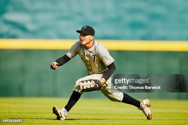 wide shot of outfielder running for catch during baseball game - catchers mitt stock pictures, royalty-free photos & images