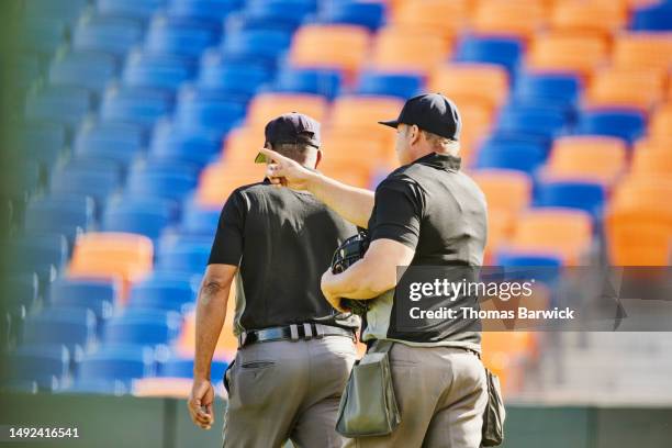 medium wide shot baseball umpires on field in stadium before game - referee shirt stock pictures, royalty-free photos & images