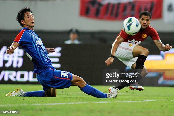 Tiago Manuel Dias Correia of Manchester United challenges with Tao Jin of Shanghai Shenhua during the Friendly Match between Shanghai Shenhua and...