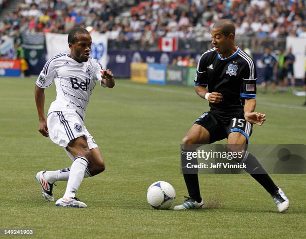 Dane Richards of the Vancouver Whitecaps FC and Justin Morrow of the San Jose Earthquakes battle for the ball during their MLS game July 22, 2012 at...