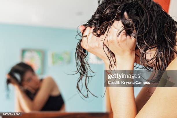 young woman taking care of her hair at home - hair care - fotografias e filmes do acervo