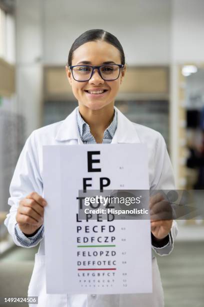 optician holding a placard with letters for an eye exam - eye chart stock pictures, royalty-free photos & images