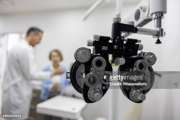 paciente en un examen ocular con el optometrista - eye test equipment fotografías e imágenes de stock