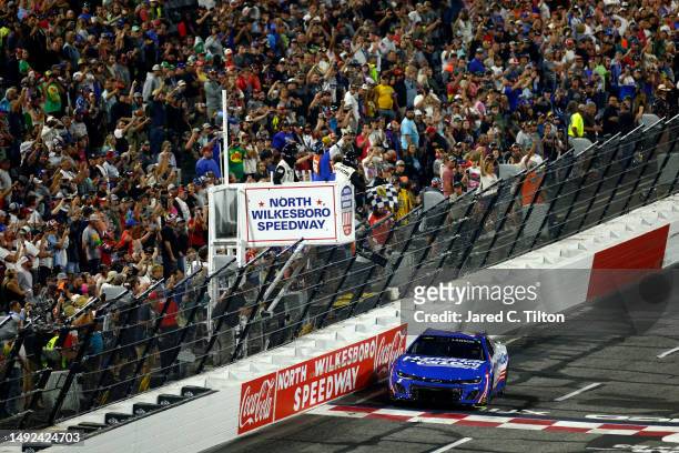 Kyle Larson, driver of the HendrickCars.com Chevrolet, takes the checkered flag to win the NASCAR Cup Series All-Star Race at North Wilkesboro...