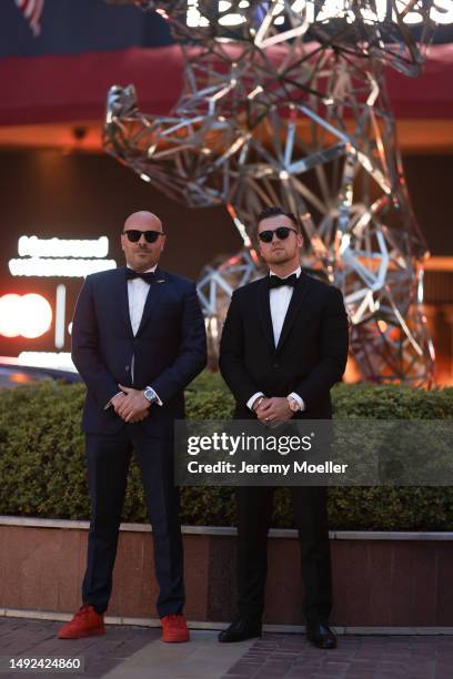 Mathieu Castanier and Austin Zelan seen wearing a black and white suit, black pants, black and red shoes and black sunglasses during the 76th Cannes...