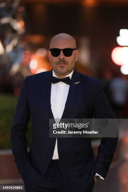 Mathieu Castanier seen wearing a black and white suit, black pants, black bow tie and black sunglasses and red shoes during the 76th Cannes film...