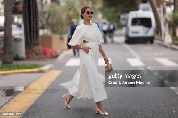 Jessica de Oliviera seen wearing Dior black sunglasses, Dior bag, Chanel heels, Rolex yellow gold watch and a flowy long dress with cutouts during...