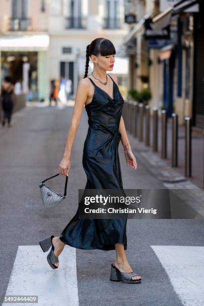 Katya Tolstova wears Prada bag, heeled sandals, black Margiela dress during the 76th Cannes film festival on May 22, 2023 in Cannes, France.