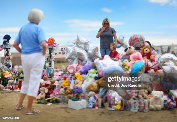 Trudy Stevens stands with her son Gavin Stevens as they visit a makeshift memorial setup across the street from the Century 16 movie theatre where...