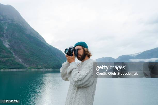 man photographing norwegian scenic landscape - man taking photos stock pictures, royalty-free photos & images