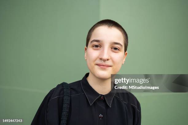 retrato de un hombre transgénero mirando a la cámara. lleva un atuendo negro genial - cabeza afeitada fotografías e imágenes de stock