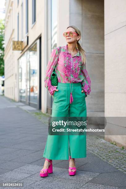 Influencer Tamara von Nayhauss, wearing green pants by Maison Common, a green-pink blouse with quilling by Maison common, pink colored high heel...