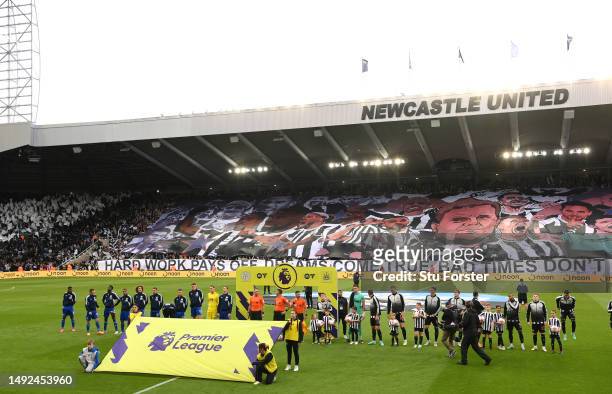 The two teams line up as a giant banner of Eddie Howe and the players is seen in the East Stand prior to the Premier League match between Newcastle...