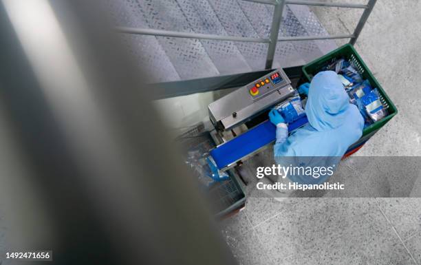 worker packing food at a processing plant using a vacuum sealer - production line stock pictures, royalty-free photos & images